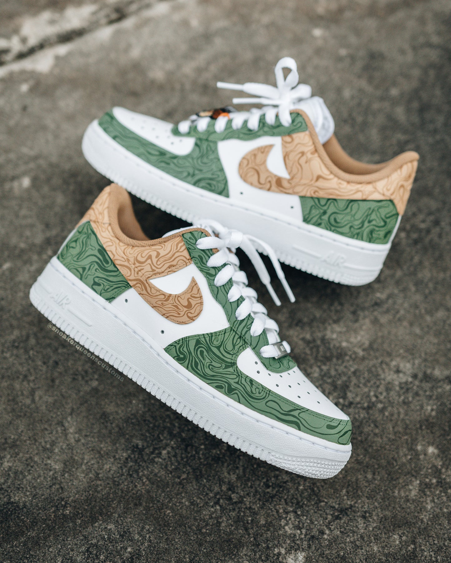 Custom Nike Air Force 1 sneakers featuring Sneaker Queens Customs’ signature Anxiety Swirls in their debut color way, with intricate green and tan topographic patterns on a white leather base.