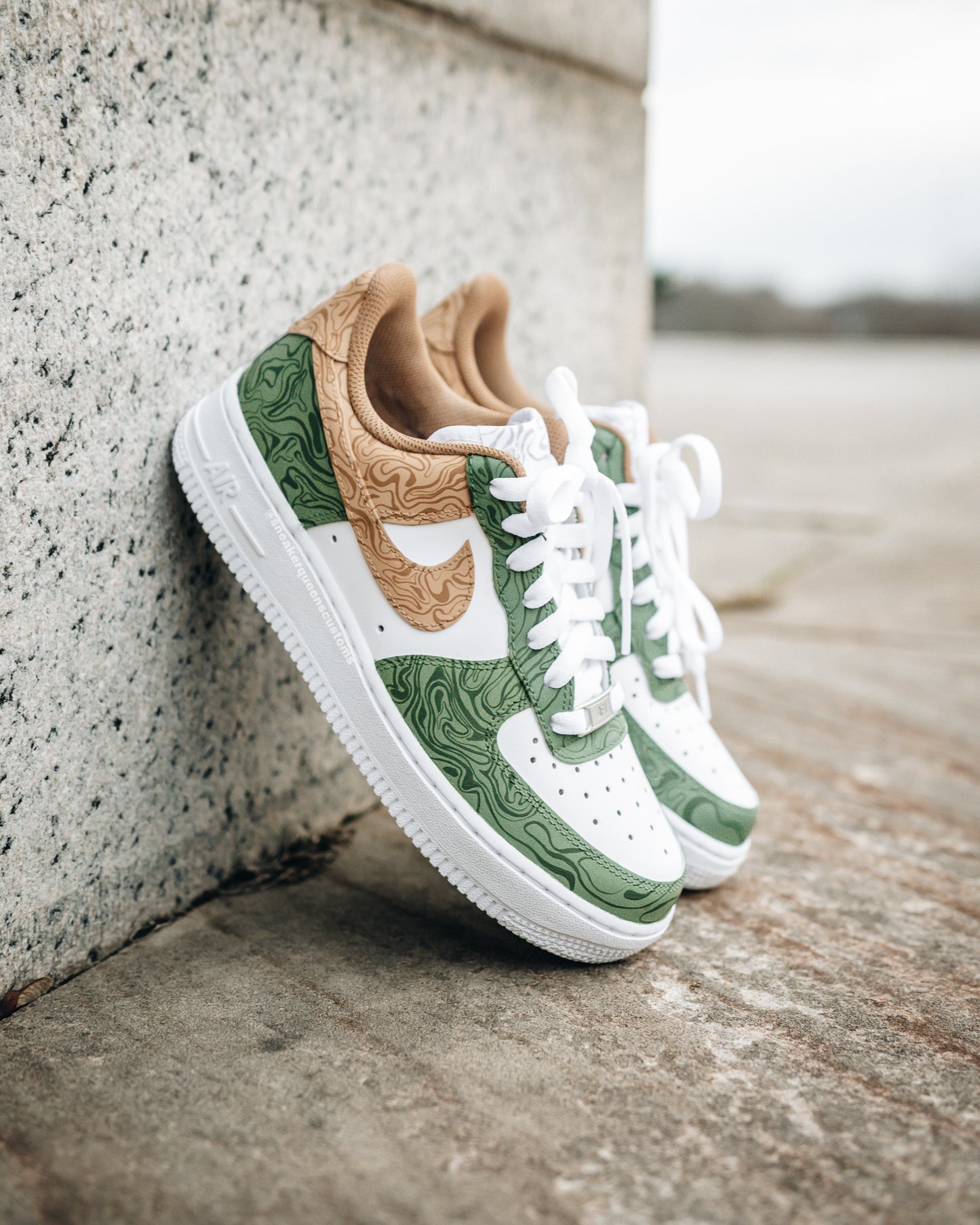 Custom Nike Air Force 1 sneakers featuring a unique design with green and tan topographic patterns on white leather, inspired by nature’s landscapes.