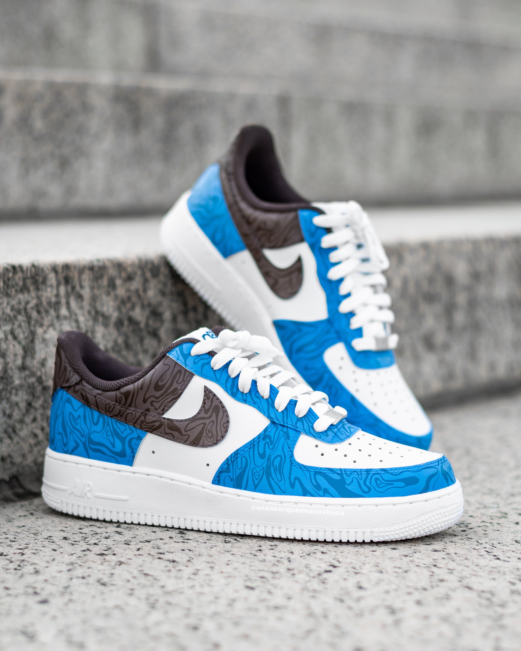 Custom Nike Air Force 1 sneakers featuring Sneaker Queens Customs’ signature Anxiety Swirls in a bold blue and brown color way, with intricate patterns on white leather.